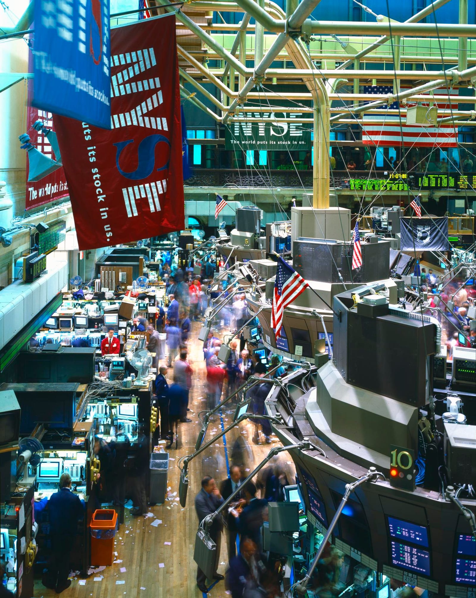 The trading floor of the New York Stock Exchange, with traders working among banks of screens and terminals.