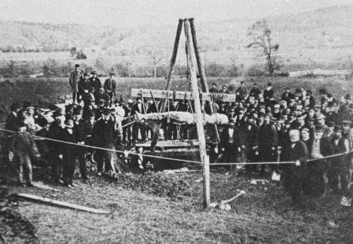 The Cardiff Giant, a large carved stone figure, lying in an open pit as workers exhume it in 1869.