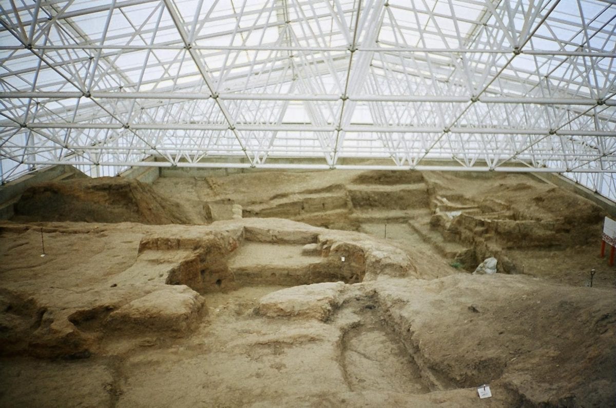 Open archaeological excavation trench at Catalhoyuk, showing exposed mudbrick walls and rooms of the Neolithic settlement.