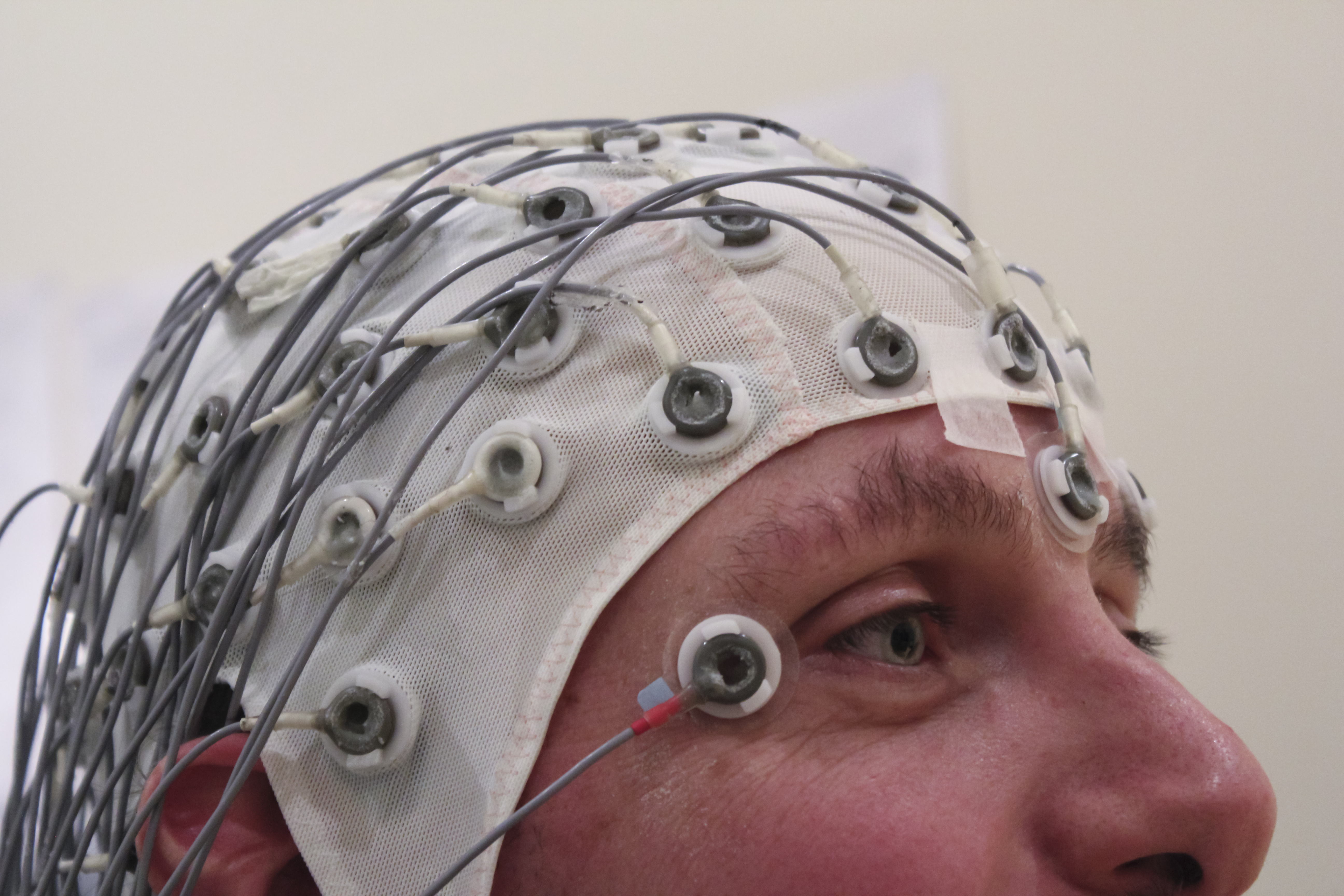 A person wearing a multi-electrode EEG cap, a non-invasive brain-computer interface
