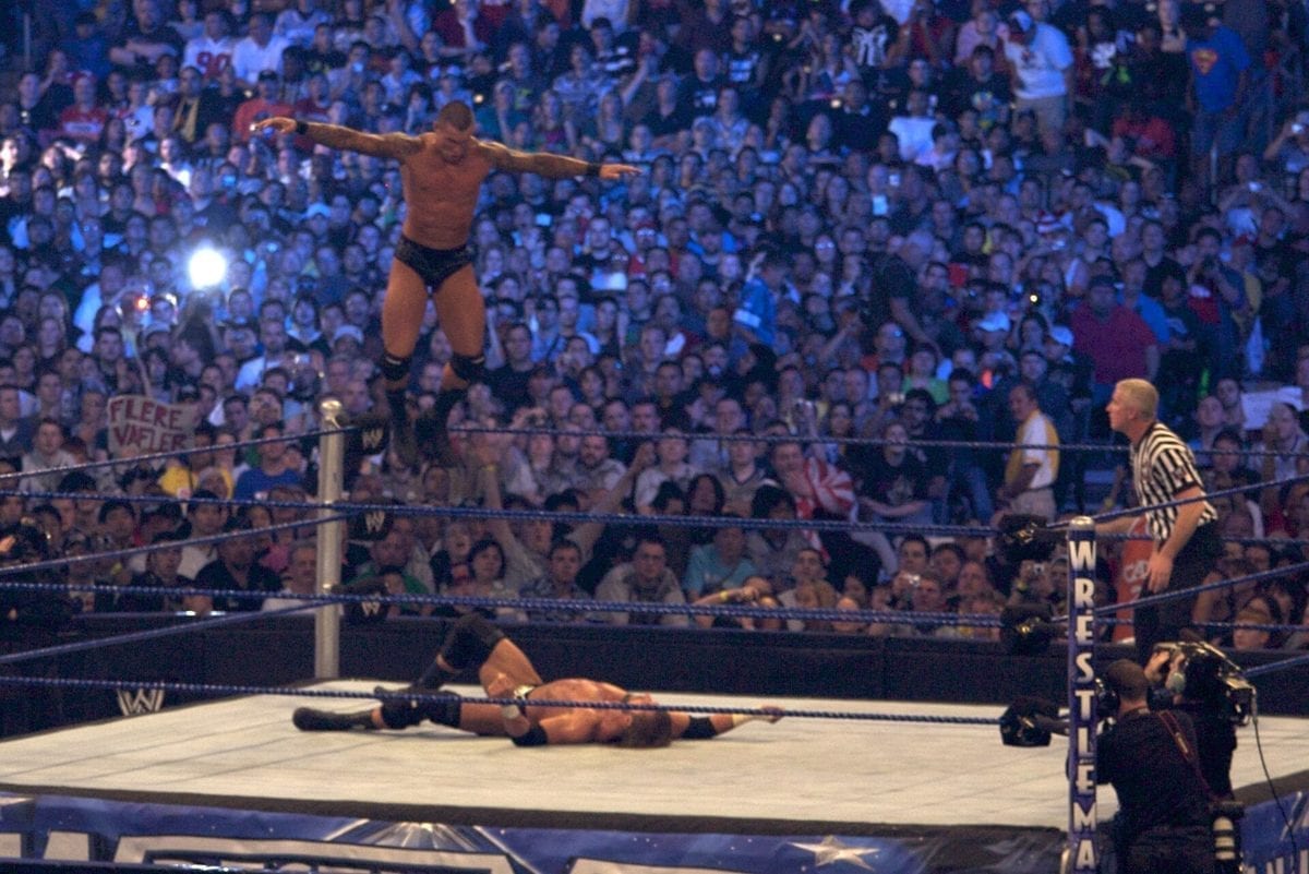 Two professional wrestlers grappling in the ring during the WWE Championship main event at WrestleMania XXV in 2009, with a large arena crowd in the background.